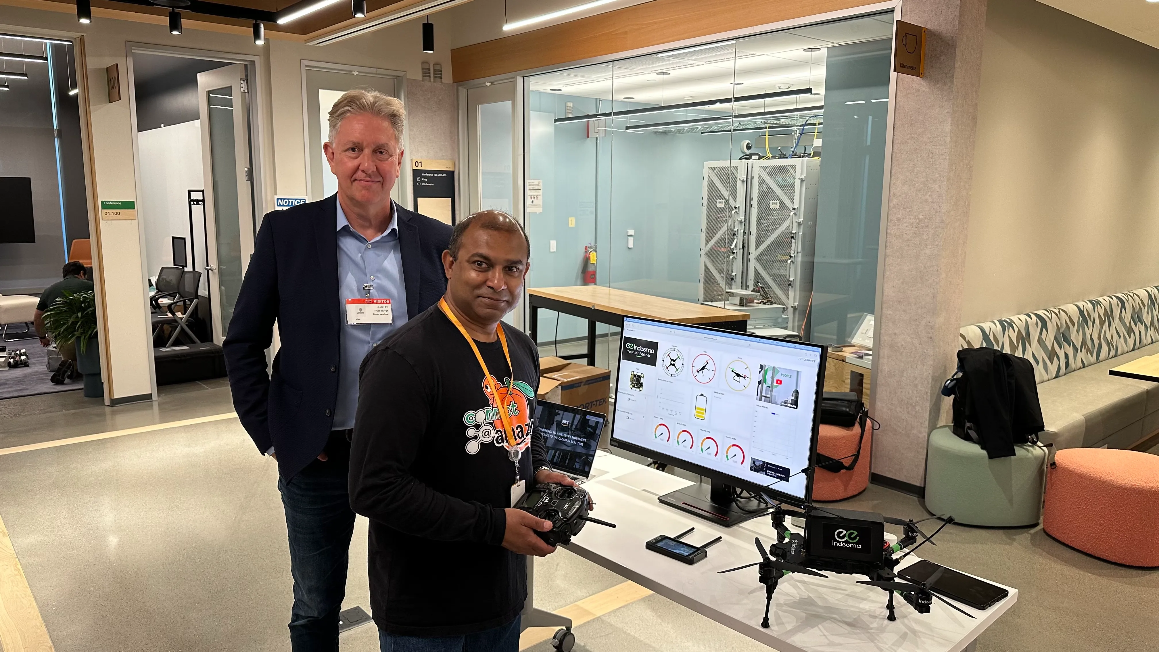 Indeema's stand with the drone prototype and people nearby